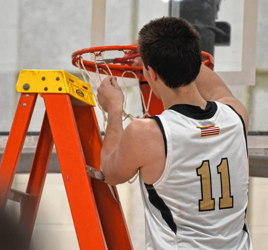 Pioneer’s Hugh Cyhowski (11) cuts down a piece of the net after the Panthers defeated Drury 54-44 in the MIAA Division 5 quarterfinal round on Saturday at Messer Gymnasium in Northfield.