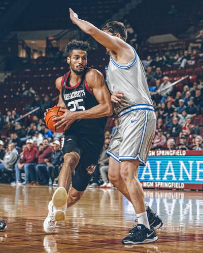 UMass’ Malek Abdelgowad (25) drives to the hoop on Saint Louis defender Robbie Avila (21) during the first half of the Minutemen’s game against the Billikens on Tuesday night at the Mullins Center in Amherst.