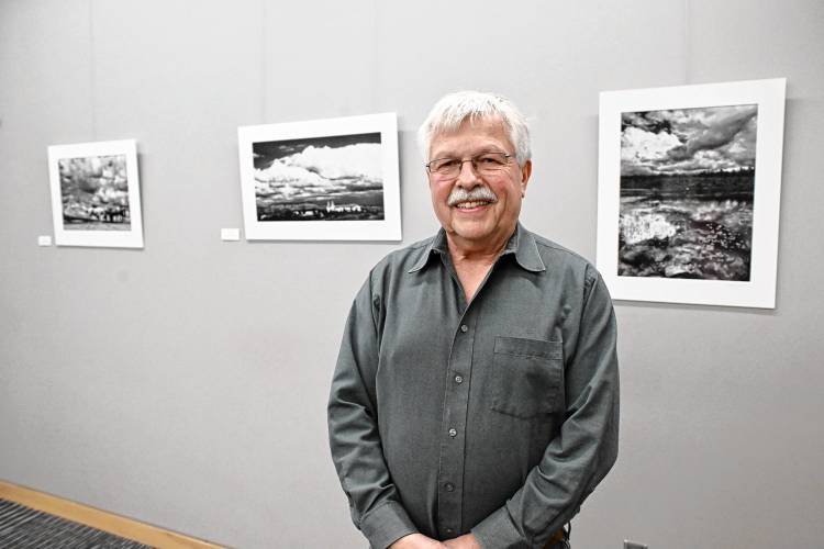 Paul Jablon with photographs from his show “Clouds in Shades of Grey,” on display at the Greenfield Public Library until the end of the month.