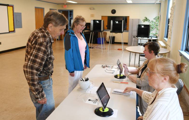 Barry and Laurie Parker are checked in to vote by Conway election workers Aimee Anderson and Michelle Harris in June 2024.