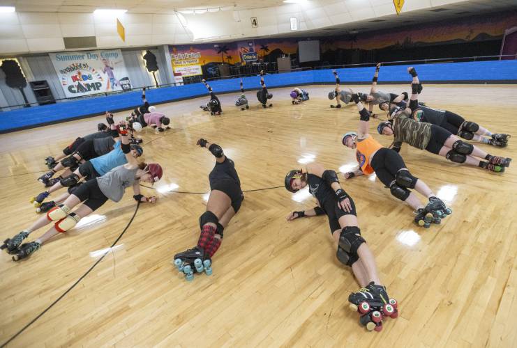 Members of the Western Massachusetts Roller Derby stretch during practice at Interskate 91 South, Thursday, April 3, 2025, in Wilbraham.