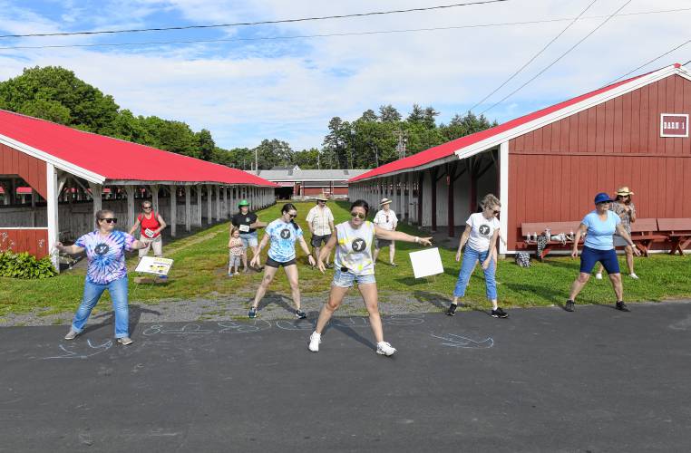 Members of Franklin County’s YMCA lead a line dance warm-up for the next group on the rodeo-themed Big Brothers Big Sisters Point 5K fundraiser on Thursday at the Franklin County Fairgrounds.