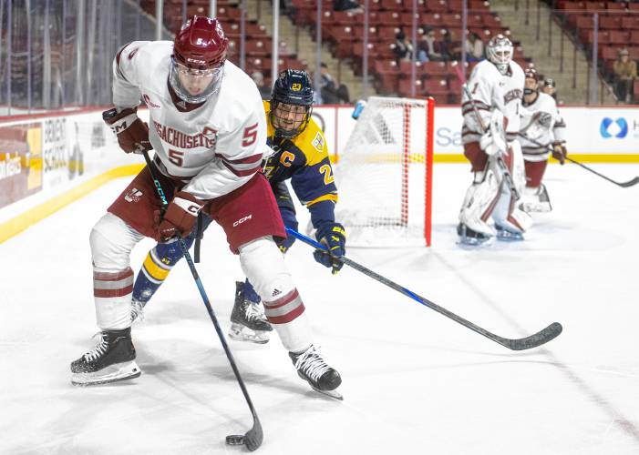 UMass defenseman Linden Alger (5) and Merrimack forward Antonio Venuto (23) compete for the puck at the Mullins Center on Saturday in Amherst.