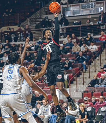 UMass guard Jaylen Curry (0) banks home a floater over a Saint Louis defender during the first half of the Minutemen’s game against the Billikens on Tuesday night at Mullins Center in Amherst.