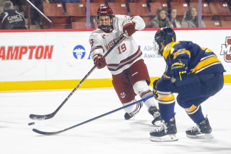 UMass right wing Cole O’Hara (19) attempts a shot, eventually scoring a goal against Merrimack at the Mullins Center on Saturday in Amherst.