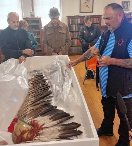 Justin Pourier, fifth member and tribal historic preservation officer of the Oglala Sioux Tribe, sings a prayer over items being returned to the Pine Ridge Reservation in South Dakota during a ceremony at Woods Memorial Library in Barre on Monday.