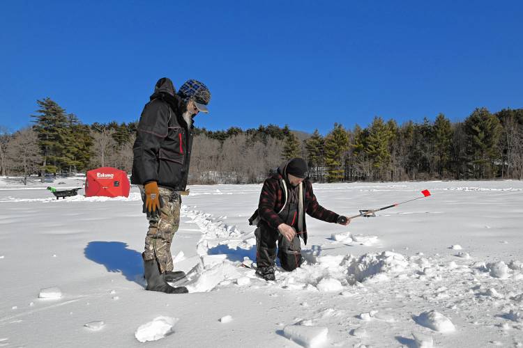 Ken Zielenski and his son Marty Zielenski check one of their tip-ups while ice fishing on Barton Cove in Gill on Wednesday. Ken Zielenski and his son Marty Zielenski check one of their tip-ups while ice fishing on Barton Cove in Gill on Wednesday.