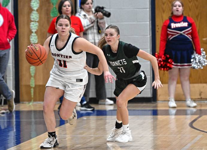 Frontier’s Claire Kirkendall is pursued by Manchester Essex’s Tess Carpenter during the Redhawks’ MIAA Division 4 Round of 32 victory at Goodnow Gymnasium in South Deerfield Thursday.
