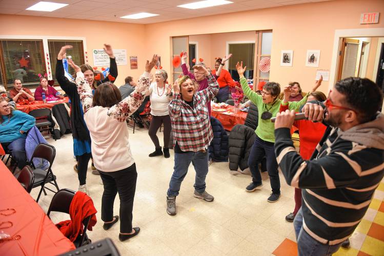 DJ Adam Vecchio, right, leads dancers through the motions accompanying the song “Y.M.C.A.” by Village People during The United Arc’s Valentine’s Day dance in Turners Falls on Wednesday evening. DJ Adam Vecchio, right, leads dancers through the motions accompanying the song “Y.M.C.A.” by Village People during The United Arc’s Valentine’s Day dance in Turners Falls on Wednesday evening.