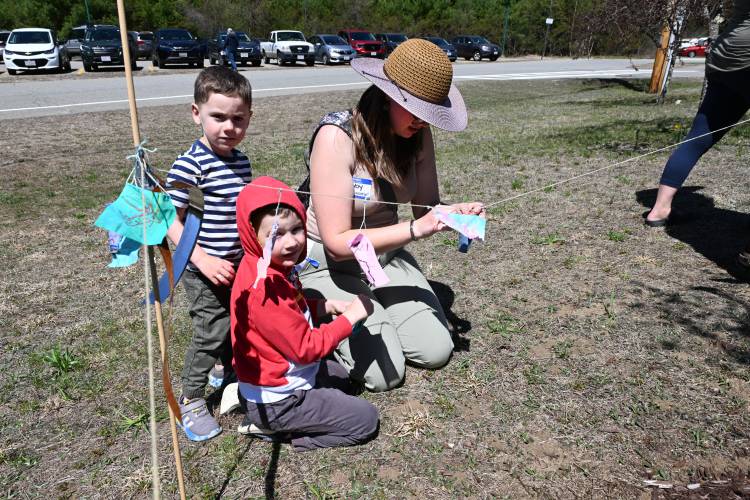 Preschool students Asher D’ambra and brother John D’ambra, with preschool assistant Abby Martin, hang wishes for the Earth on a string protecting a newly planted tree during a belated Earth Day celebration at Warwick Community School on April 30. The tree was dedicated to Rod Whipple, who was the tree warden in town and has also held several other positions.
