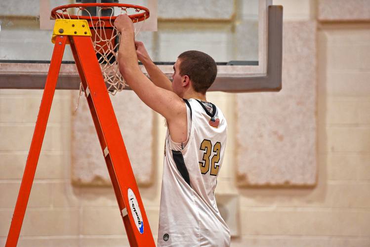 Pioneer senior Josh Wood (32) cuts down a piece of the net after the Panthers’ 54-44 victory over Drury in the MIAA Division 5 quarterfinal round on Saturday at Messer Gymnasium in Northfield.