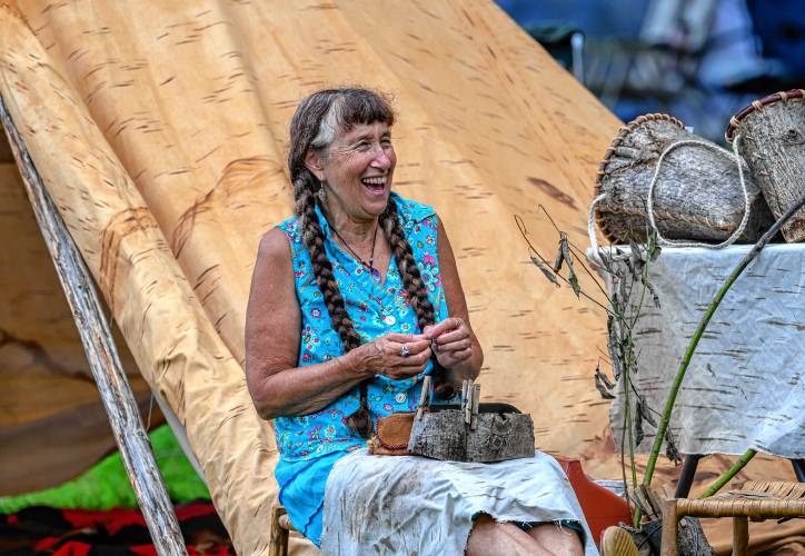 Plainfield resident Jennifer Lee laughs while working on a bark basket during the Pocumtuck Homelands Festival, celebrating Native American art, music, and cultures at Unity Park in Turners Falls on Saturday.