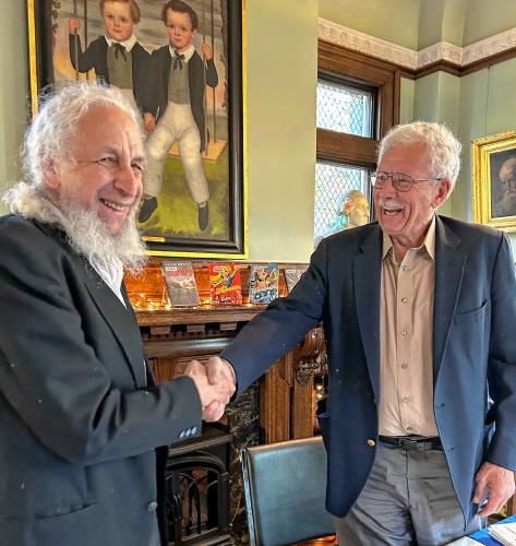 Town moderator candidates Joe Kurland and Michael Slowinski shake hands before addressing voters’ questions at Colrain’s Candidates Night at Griswold Memorial Library last week.