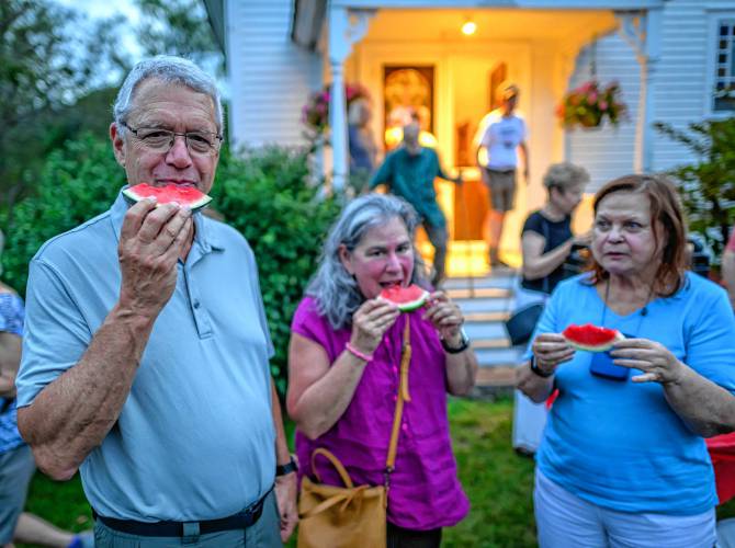 Attendees help themselves to sliced watermelon at intermission during a Watermelon Wednesdays concert at the West Whately Chapel.