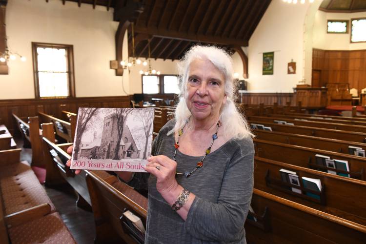 Greenfield’s All Souls Church Chair of Worship Kate Mason with the recently published book “200 Years at All Souls,” documenting with photos and historical texts, the congregation’s two-century history in Greenfield.