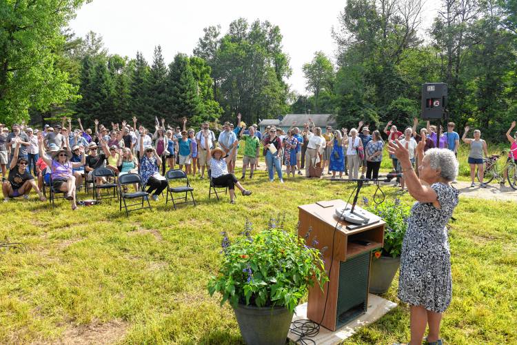 Elaine Puleo, chair of the Shutesbury Library Building Committee, welcomes those in attendance at a groundbreaking ceremony on Friday morning for the new Shutesbury library. The show of hands was for people who had participated in fundraisers for the new building.