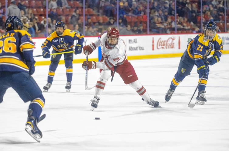 UMass left wing Bo Cosman, center, controls the puck during Saturday’s game against Merrimack at the Mullins Center in Amherst.