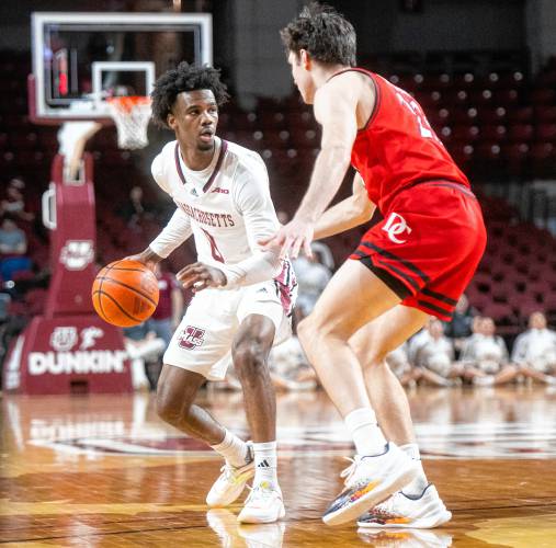 UMass guard Jaylen Curry, left, keeps the ball from Davidson guard Connor Kochera, right, during the college basketball game at the Mullins Center, Wednesday, Feb. 12, 2025, in Amherst.