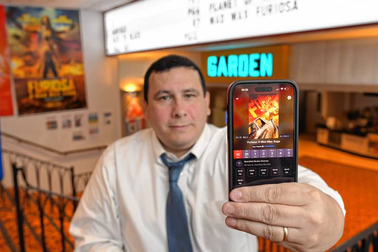 Isaac Mass of Greenfield’s Garden Cinemas displays the TheaterEars app on his phone that allows viewers to hear movies in Spanish. 