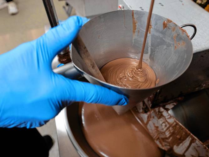 Christopher Owen fills the funnel with milk chocolate to make nonpareils in preparation for Valentine’s Day at Richardson’s Candy Kitchen.