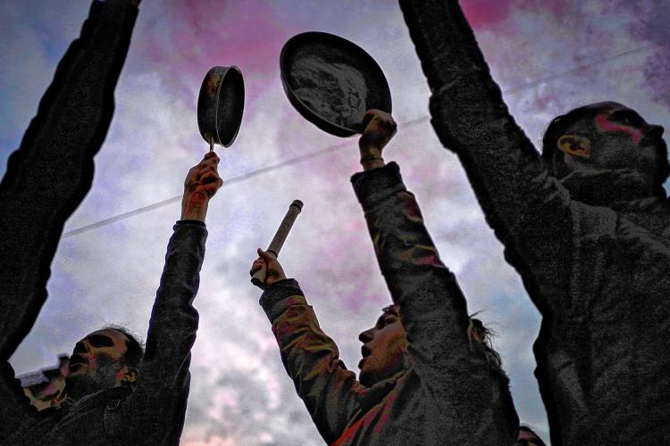 People bang pots and pans while French President Emmanuel Macron speaks in a televised address to the nation on April 17, 2023 in Paris as French demonstrations have been marked by citizens making noise by banging kitchen saucepans.