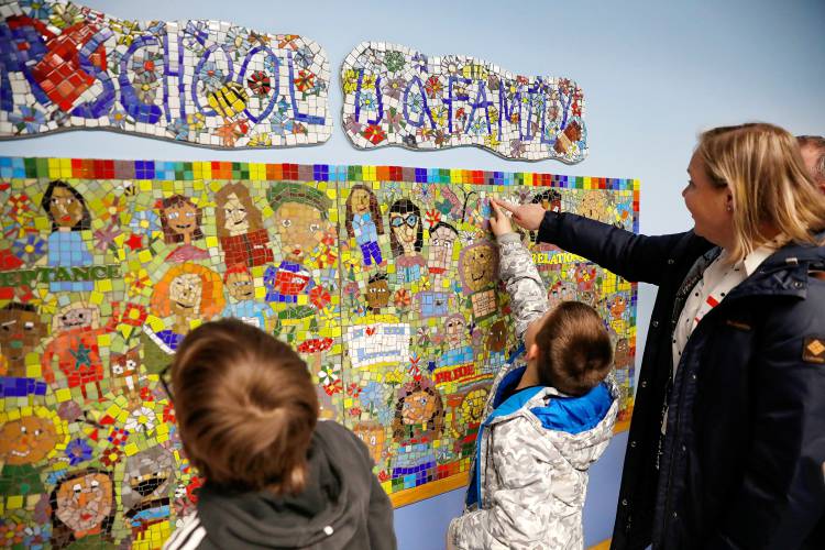 Connor Bergeron, 8, shows his mother Melissa sections he worked on the Mosaic Tile Project, which features a multicultural theme, Thursday during the annual International Night at Sunderland Elementary School. 
