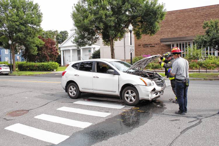 Greenfield emergency personnel inspect a white Nissan Rogue involved in an alleged hit-and-run on Main Street on Monday afternoon. Greenfield emergency personnel inspect a white Nissan Rogue involved in an alleged hit-and-run on Main Street on Monday afternoon.