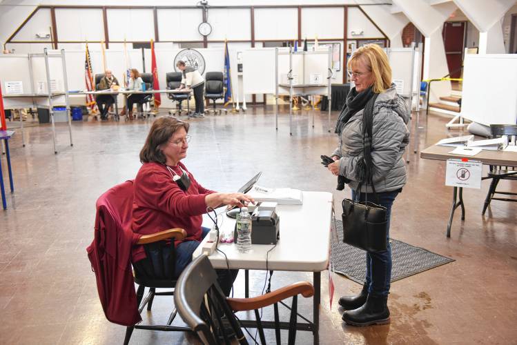 Deerfield election worker Julie Cavacco checks resident Barbara Miskimen in to vote in the Deerfield special election on Tuesday.