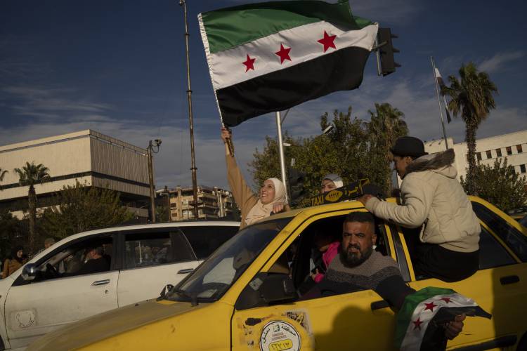 A woman waves a Syrian opposition flag in celebration days after the fall of Bashar Assad’s government in Damascus.
