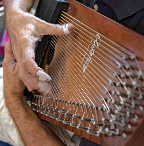 Richard Ballon plays the autoharp during the weekly workshop hosted by Marie Hartwell-Walker at the Amherst Senior Center.