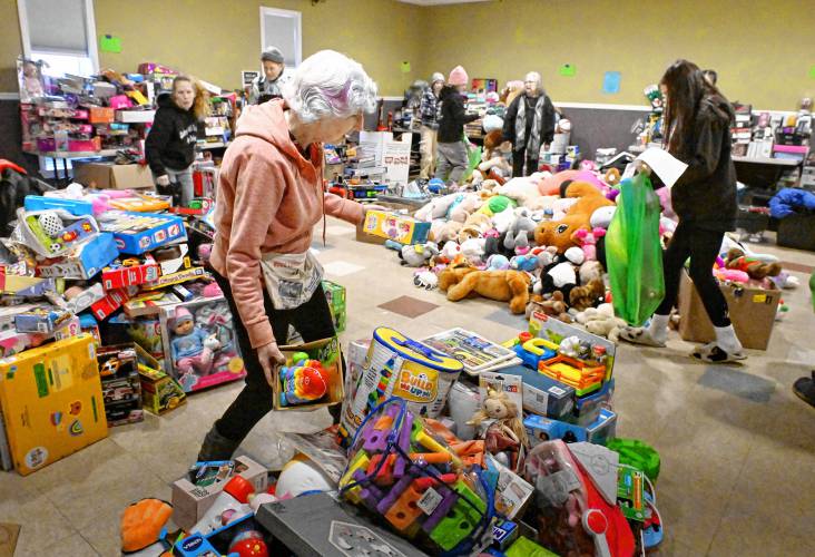 Turners Falls resident Lillian Moss gathers presents for Giving Back Together Toy Drive recipients at Faith Church on Silver Street in Greenfield on Friday.