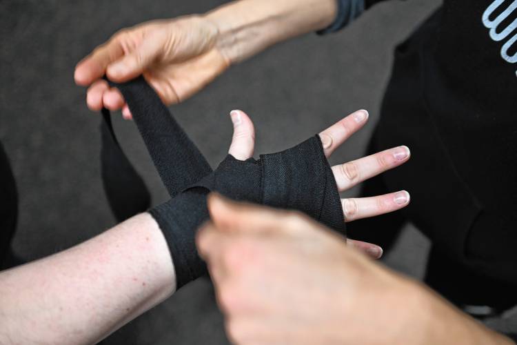 Boxing instructor Vanessa Chakour wraps Greenfield Recorder reporter Madison Schofield’s hands at Franklin County’s YMCA.