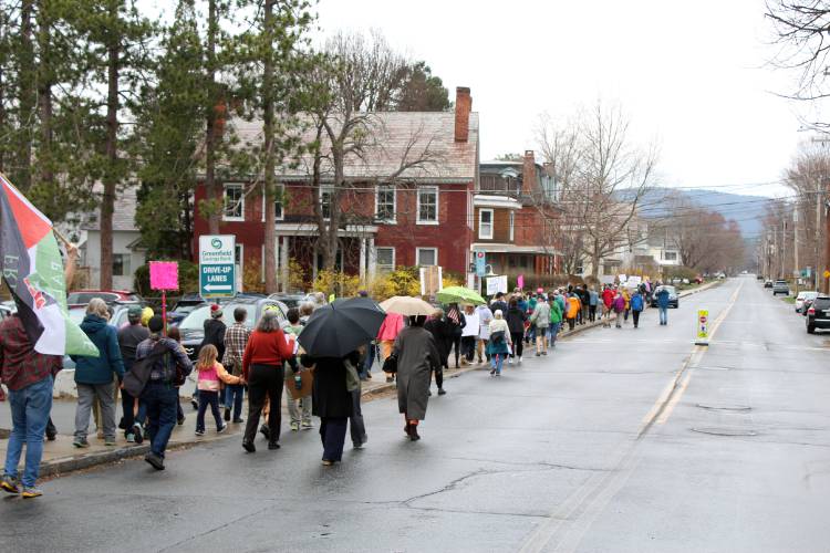 Protesters march through Shelburne Falls in opposition to the Trump administration on Saturday.