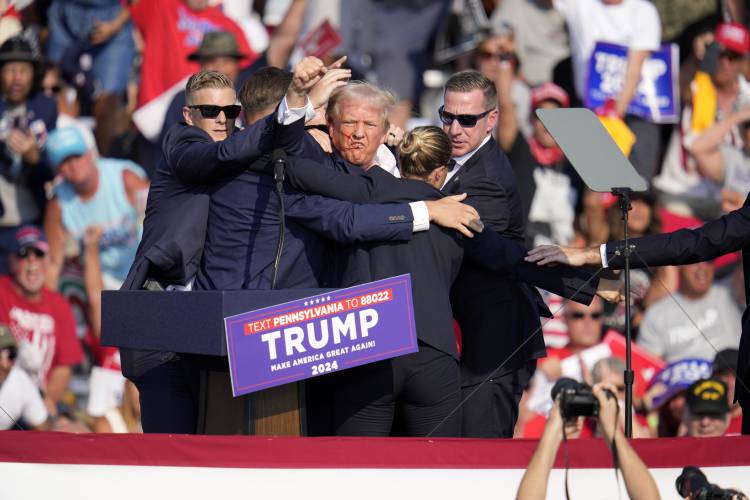 Republican presidential candidate former President Donald Trump is surrounded by U.S. Secret Service agents at a campaign event in Butler, Pa., Saturday, July 13, 2024. (AP Photo/Gene J. Puskar)