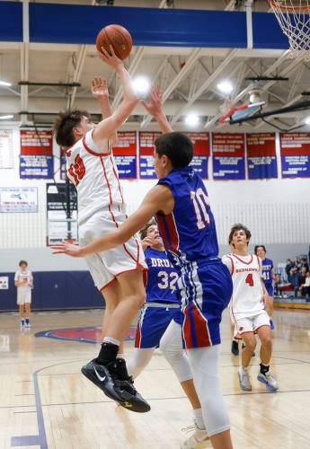 Frontier’s Max Millette (10) puts up a shot over Drury defender Jorge Bond (10) in the second quarter Friday night at Goodnow Gymnasium in South Deerfield.