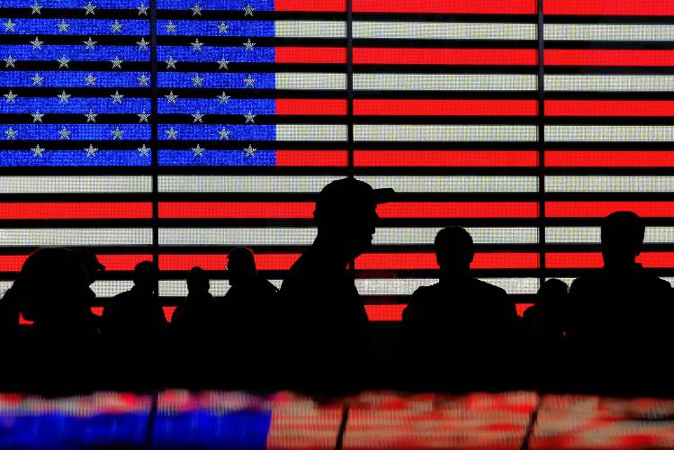 People gather near an electronic display of an American flag in Times Square in New York on Aug. 9, 2024.