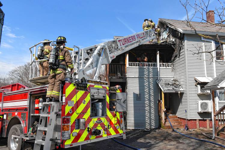 Firefighters extinguish a fire that scorched the rear of a two-family residence at 20 Elm St. in Greenfield on Wednesday.