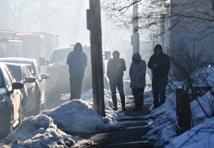 Smoke filled Osgood Street as people watch an apartment house fire Sunday morning at 75 School St. in Greenfield.