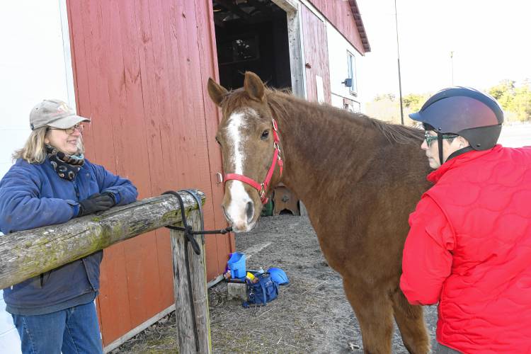 Deb Gordon, president and instructor of the Courageous Strides therapeutic riding program, pictured at Stoney B Acres in Bernardston in March 2024 with Logan and veteran Lori-Lee Adams. Though Stoney B Acres has served as the program’s host farm since 2016, the program is now looking for a new space. Deb Gordon, president and instructor of the Courageous Strides therapeutic riding program, pictured at Stoney B Acres in Bernardston in March 2024 with Logan and veteran Lori-Lee Adams. Though Stoney B Acres has served as the program’s host farm since 2016, the program is now looking for a new space.