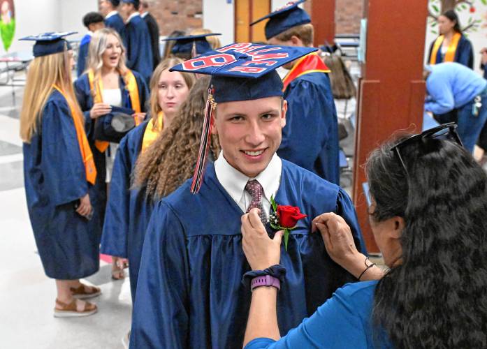 Frontier Senior Rosco Palmer gets a rose pinned to his gown prior to Frontier Regional School graduation on Friday Night in South Deerfield.