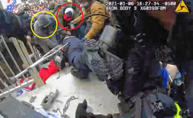 In this image from a police body camera Logan Barnhart, circled at left, is shown grabbing an officer and dragging him into the crowd of rioters at the Capitol on Jan. 6, 2021