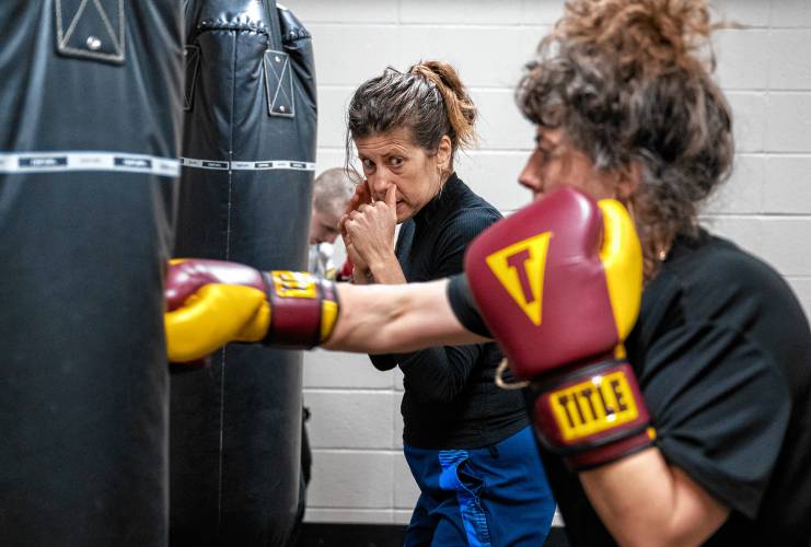 Instructor Vanessa Chakour, back, watches Anna Knecht-Schwarzer train on a heavy bag during her women's boxing class at Franklin County's YMCA.