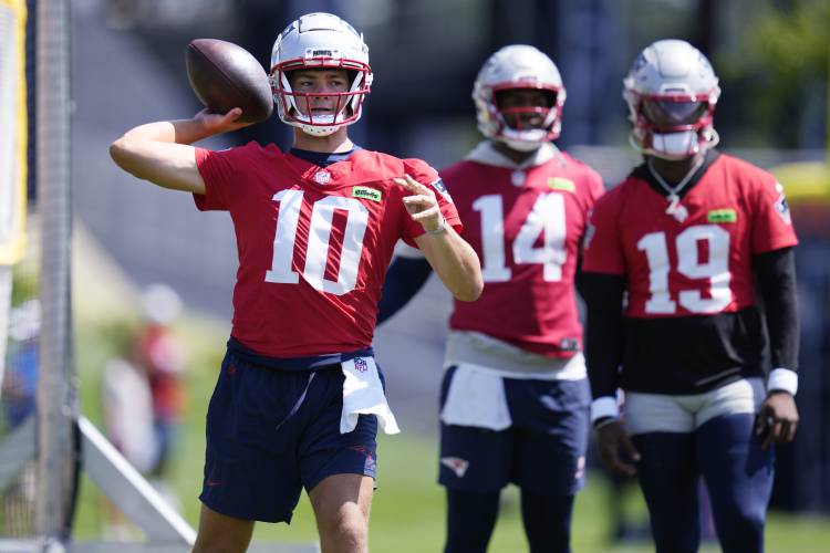 New England Patriots quarterback Drake Maye (10) throws as Jacoby Brissett (14) and Joe Milton III (19) look on during an NFL football training camp, Friday, July 26, 2024, in Foxborough, Mass. (AP Photo/Charles Krupa)