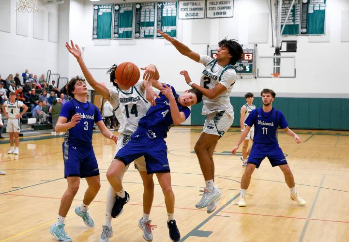 Greenfield’s Malik Moore (14) and Krish Patel (2) defend against Wahconah’s Cooper Calvert (4) in the fourth quarter Saturday night in Greenfield.
