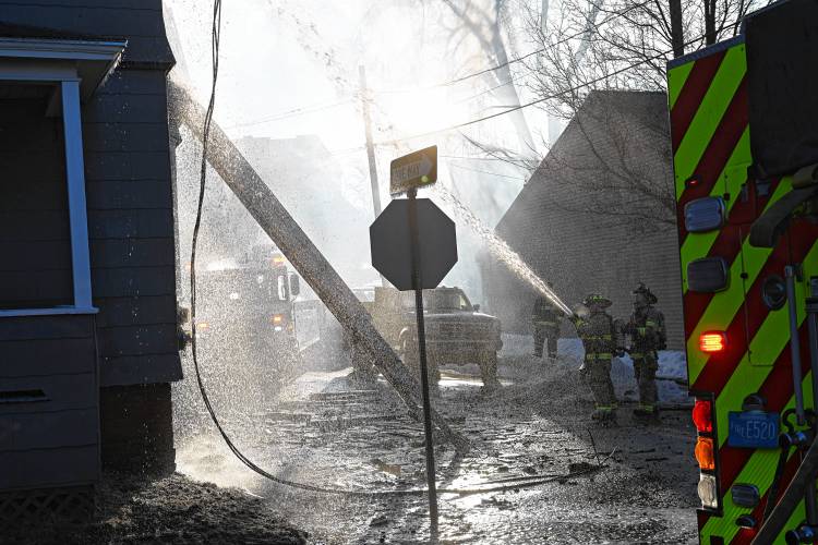 Firefighters battle freezing conditions fighting an apartment house fire Sunday morning at 75 School St in Greenfield..