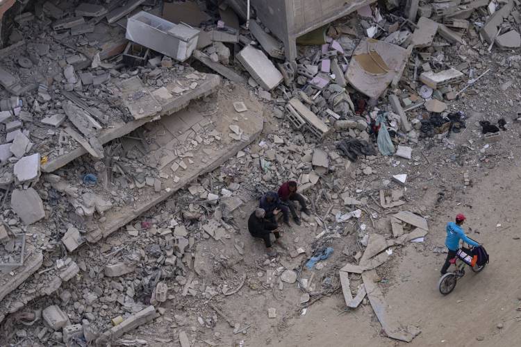 Palestinians walk through the destruction in the wake of an Israeli air and ground offensive in Khan Younis, southern Gaza Strip, Monday, April 8, 2024. Palestinians walk through the destruction in the wake of an Israeli air and ground offensive in Khan Younis, southern Gaza Strip, Monday, April 8, 2024.