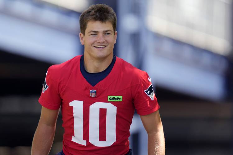 New England Patriots quarterback Drake Maye smiles while heading towards the practice field during an NFL football training camp, Friday, July 26, 2024, in Foxborough, Mass. (AP Photo/Charles Krupa)