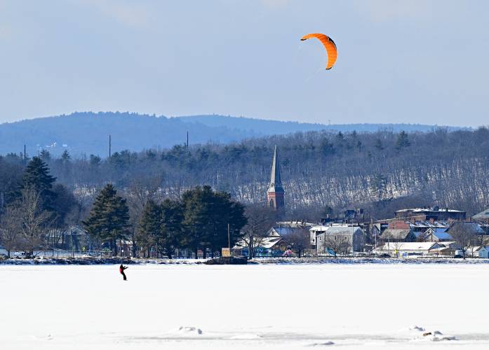 An individual is pulled along by a parachute while on skis on Barton Cove as seen from Gill on Friday. Similar to alpine paraskiing, where one can ski off a cliff or jump and glide to the next point, this individual stayed on the snow-packed ice. An individual is pulled along by a parachute while on skis on Barton Cove as seen from Gill on Friday. Similar to alpine paraskiing, where one can ski off a cliff or jump and glide to the next point, this individual stayed on the snow-packed ice.