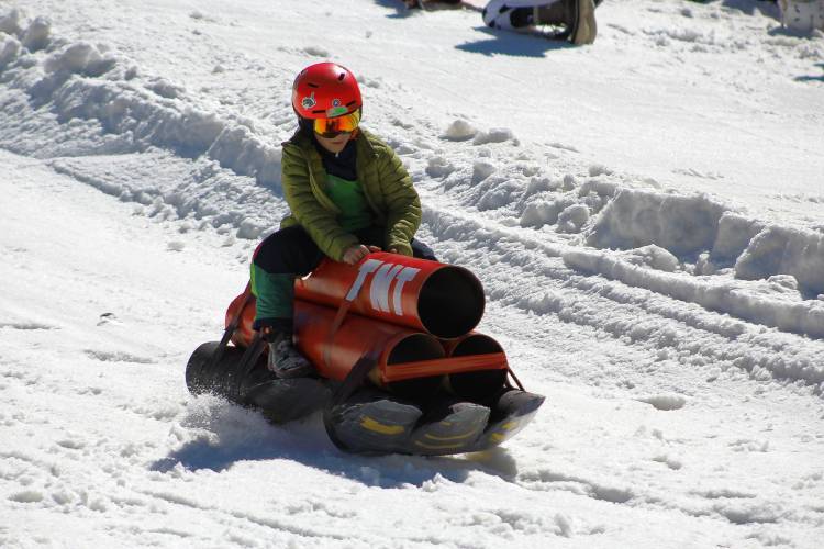 Northampton resident Thatcher Sirota races down the hill on his cardboard sled, crafted to look like a stack of dynamite, during Sunday’s Cardboard Classic sled race at Berkshire East Mountain Resort in Charlemont.