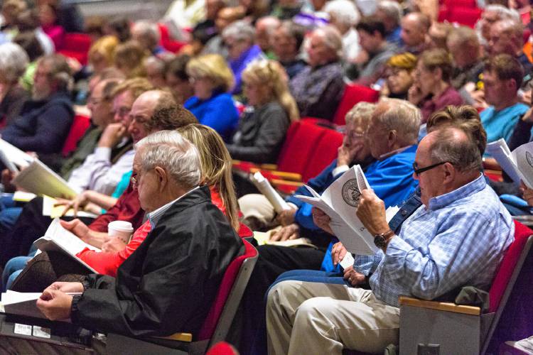Voters at Deerfield’s 2016 Annual Town Meeting look over the budget at Frontier Regional School. In an effort to boost participation at Annual Town Meeting this year, Deerfield will offer child care for the first time.